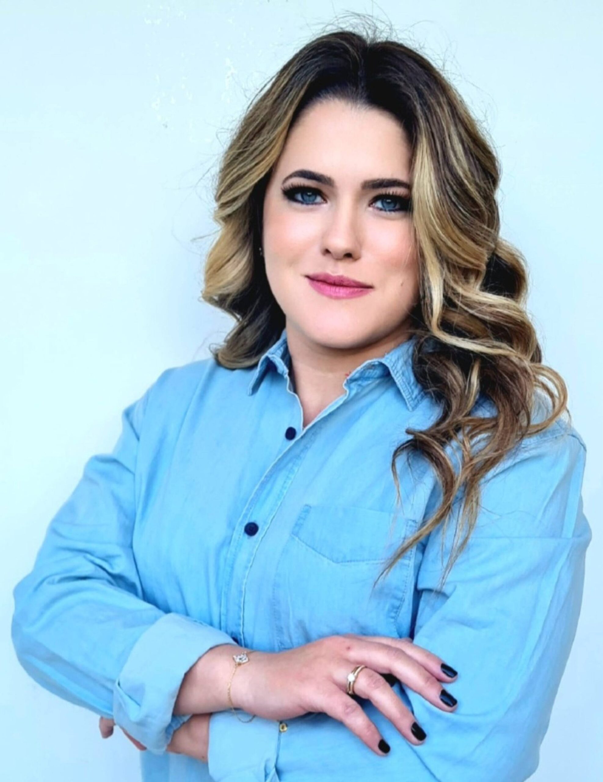 Amanda Tolfo Porto author for Spektrumlab Professional portrait of Amanda Tolfo Porto wearing a light blue shirt with her arms crossed against a pale blue background.