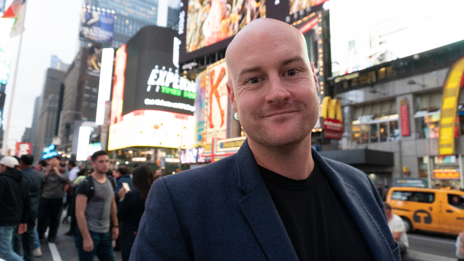 Craig Cobb for Sperkrum.io Craig Cobb standing in Times Square, New York, with digital billboards and city traffic in the background.